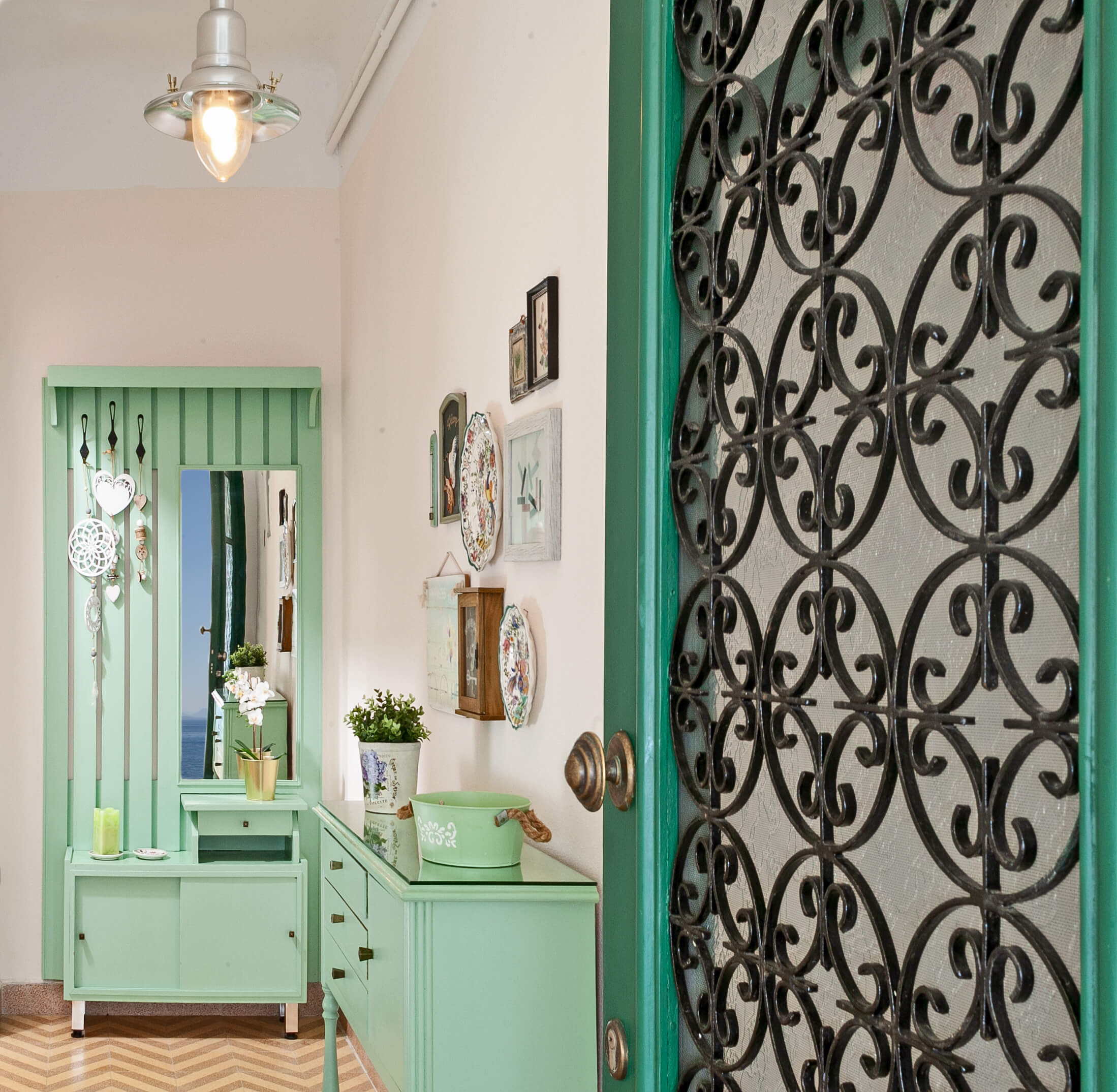 Charming entrance hallway with vintage-style decor, including a mirror, hooks, and ornamental details, at Avgi by the Sea, Pelion Villas.