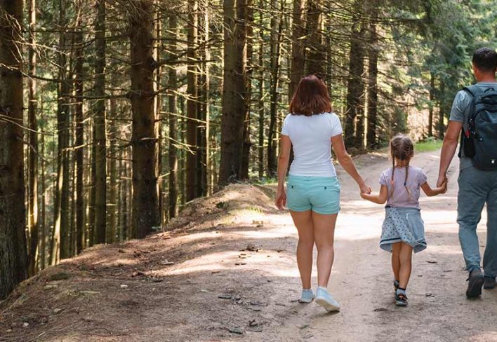 family-hiking-pelion A family hiking along a forest trail in Pelion, Greece.