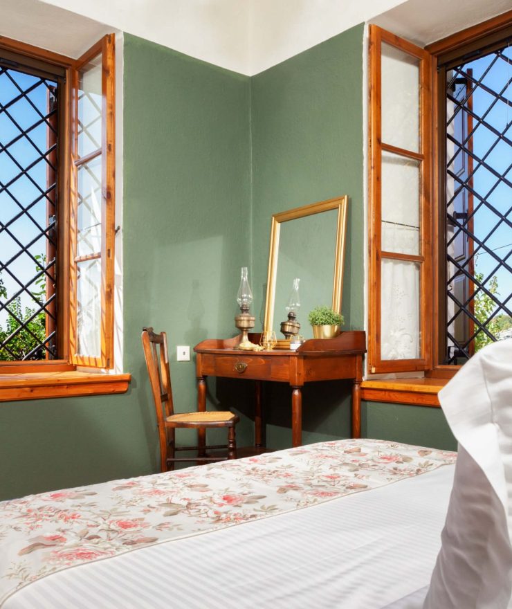 Bedroom1 windows-Villa Erifili Παραδοσιακή κρεβατοκάμαρα με πράσινους τοίχους και ξύλινα παράθυρα στη Villa Erifili από το Pelion-villas.com.