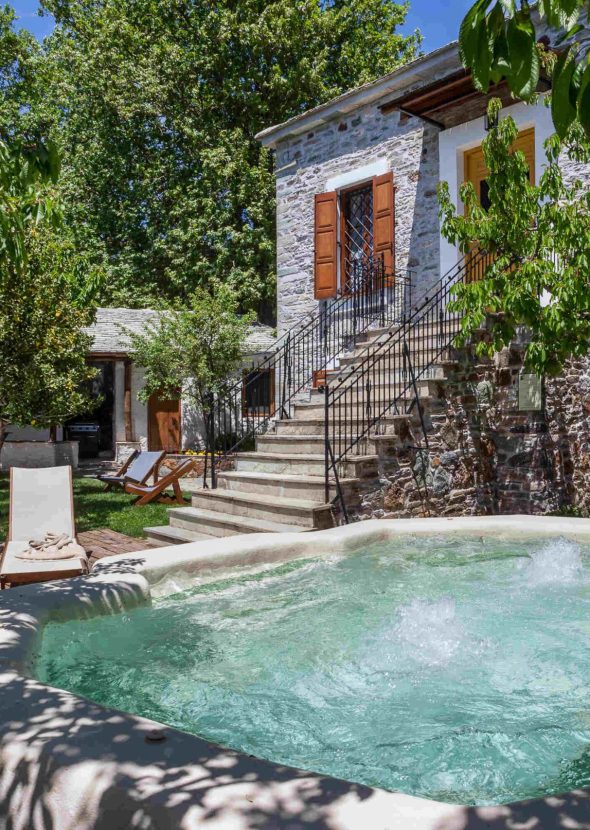 Εξωτερικό τζακούζι περιτριγυρισμένο από καταπράσινη βλάστηση και ξαπλώστρες στη Villa Erifili από το Pelion-villas.com.