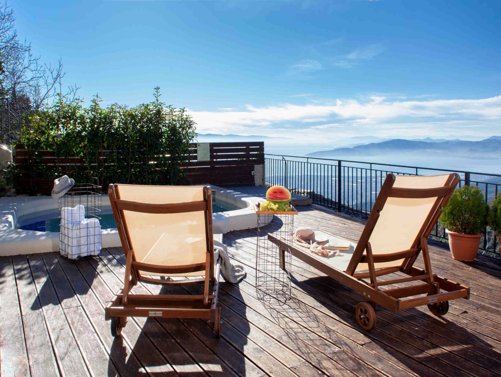 Ξύλινη βεράντα με ξαπλώστρες, φρέσκα φρούτα και εντυπωσιακή θέα στα βουνά στη Villa Evridiki, Pelion-villas.com.