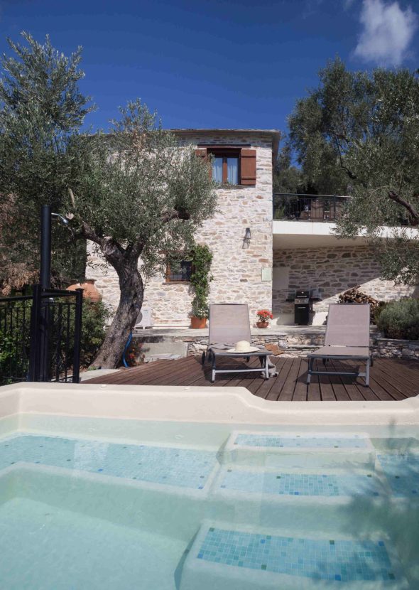 villa-ioanna-eksoteriki-pisina-pelion Μια ήρεμη πισίνα με ξαπλώστρες μπροστά από τη λιθόκτιστη Villa Ioanna, περιτριγυρισμένη από ελαιόδεντρα, στο Pelion-villas.com.