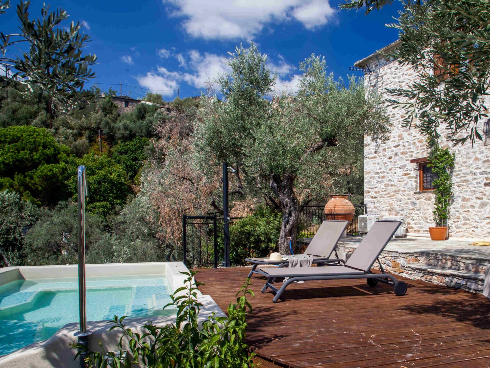 Ground floor terrace-Villa Ioanna Εξωτερική πισίνα με ξαπλώστρες, περιτριγυρισμένη από ελαιόδεντρα και πέτρινους τοίχους στη Villa Ioanna, Pelion-villas.com.