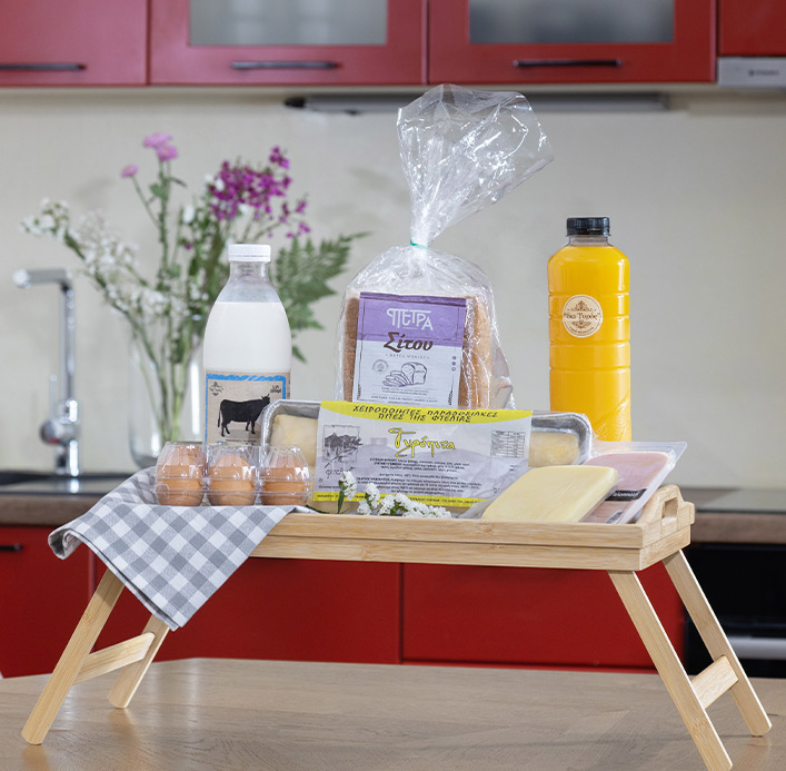 Breakfast tray with fresh bread, eggs, milk, orange juice, and handmade pies, featuring Greek local products by Pelion-villas.com.