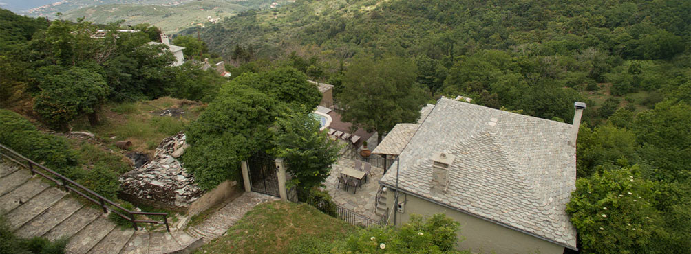 Traditional Pelion villa surrounded by lush green forest landscape at Pelion Esties