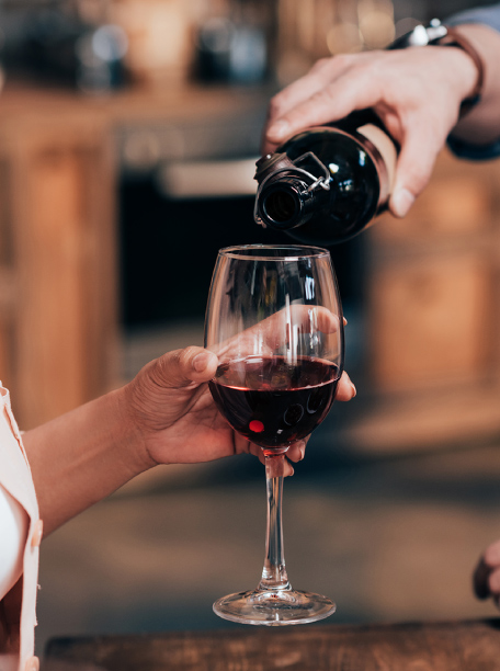 A glass of red wine being poured during a wine-tasting event near Pelion-villas.com.