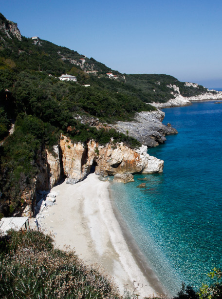 A secluded beach with turquoise waters and rocky cliffs in Pelion, Pelion-villas.com.