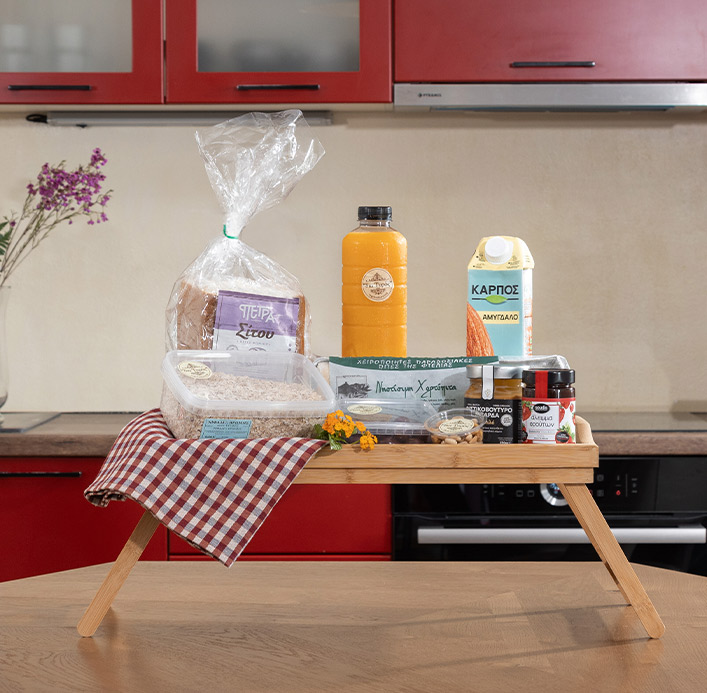 A tray with vegan Greek breakfast essentials, including bread, orange juice, almond milk, and honey showcased by Pelion-villas.com.