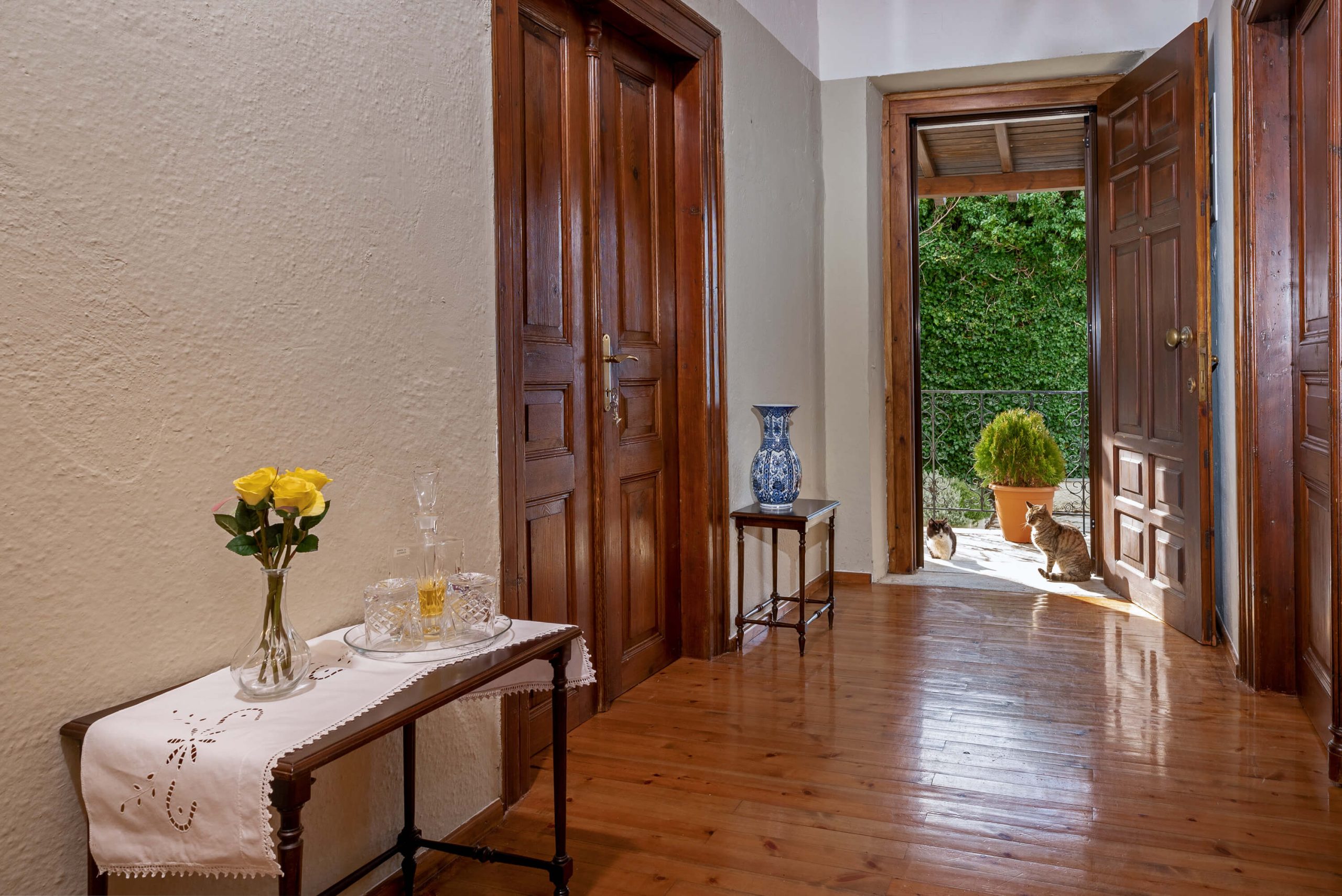 Ζεστός διάδρομος με ξύλινες πόρτες, κομψή διακόσμηση και θέα στον κήπο στη Villa Evridiki, Pelion-villas.com.